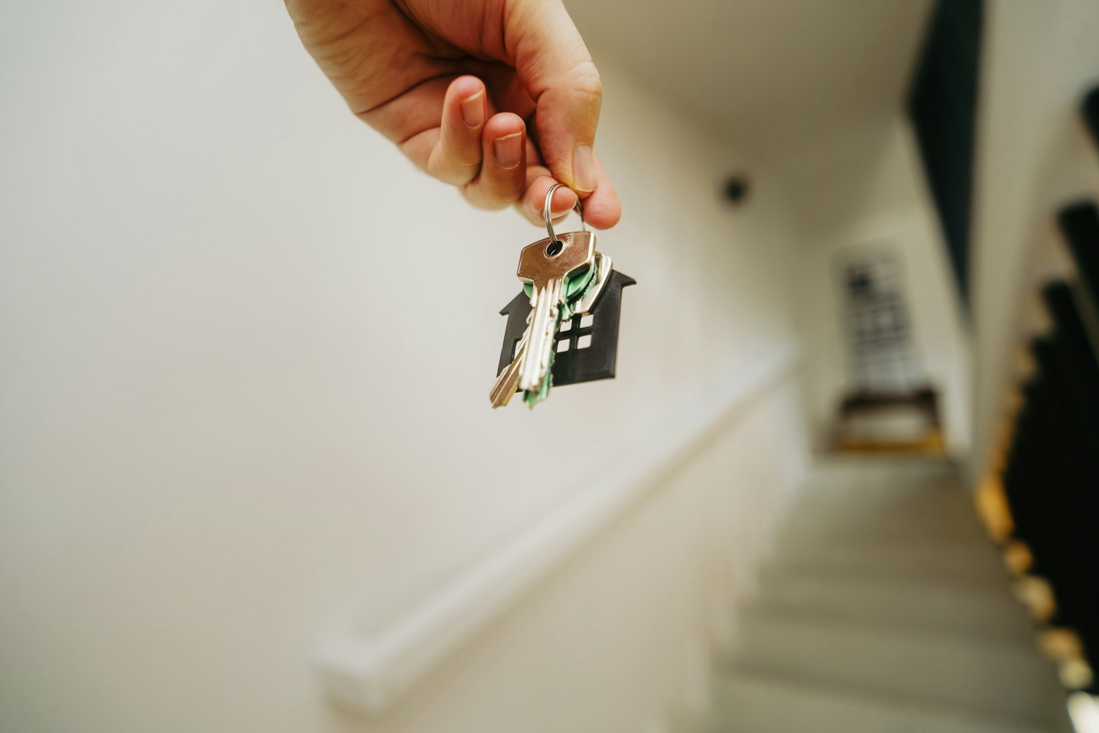 Person holding house keys in a stairwell