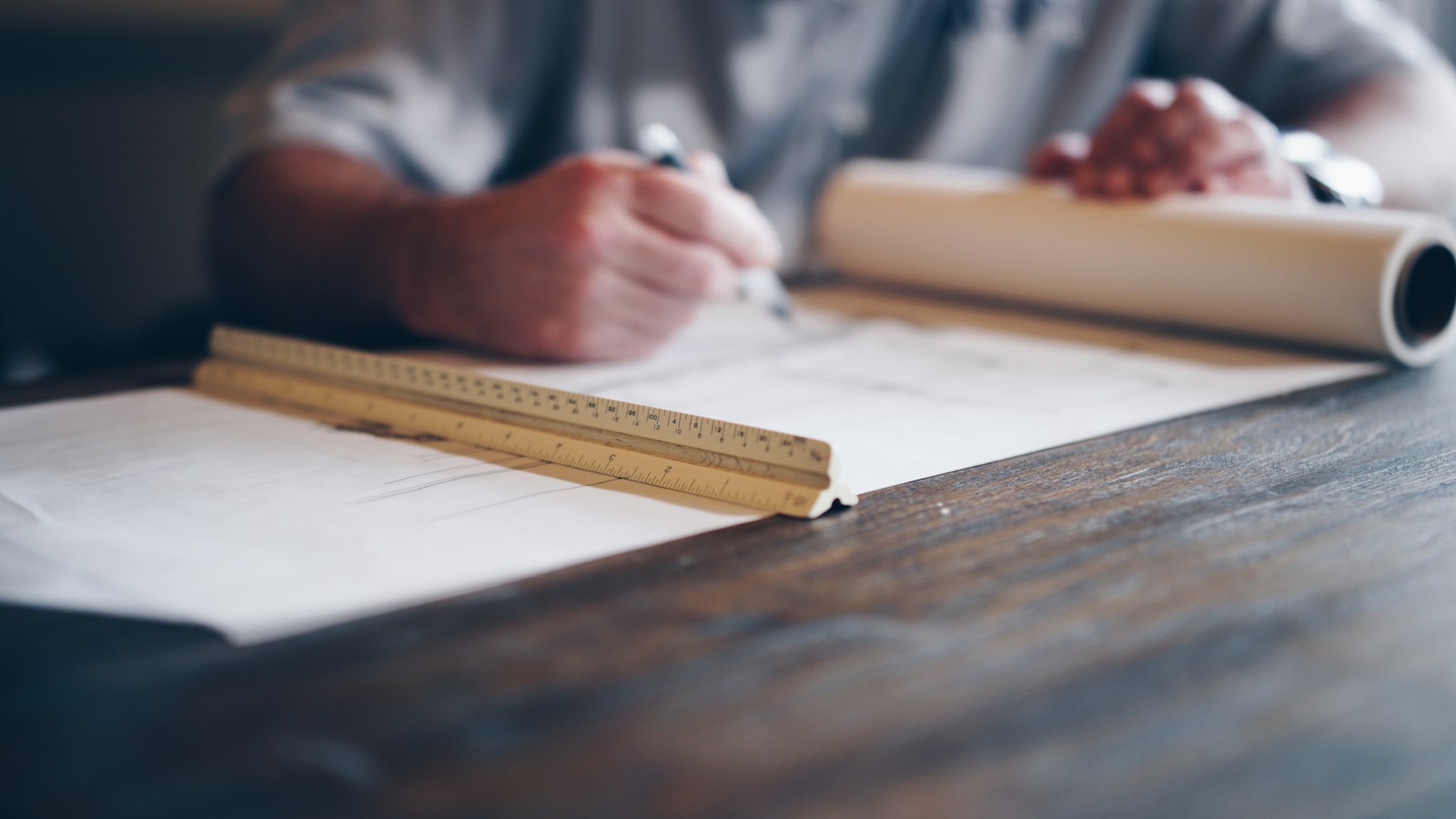 Person drafting on architectural plans